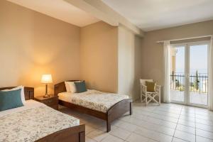 a bedroom with two beds and a balcony at Villa Mihas in Vlachata +24 photos