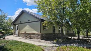a small green house with a stone foundation at Mountain View Home on 2 Acres in Bozeman