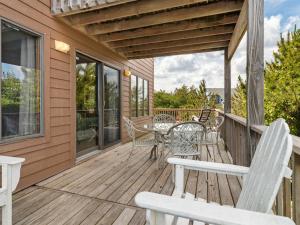 a wooden deck with chairs and a table on it at 2030 - Horizon`s Summit in Duck +63 photos