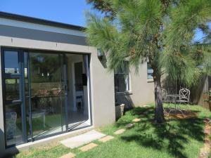 a palm tree in front of a house at Sunbird Cottage in Noordhoek