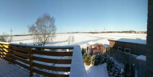 Ferienwohnung Berne في Berne: شرفة تطل على حقل مغطى بالثلوج في الخلفية