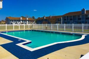 a swimming pool in a yard with a fence at Hidden Harbour -- 306 Ocean View Parkway in Bethany Beach