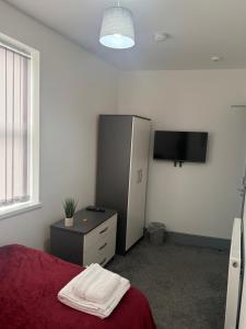 ein Schlafzimmer mit Bett, Kommode und Fernseher in der Unterkunft PLUS Properties Dike 3 Ensuite in Stoke on Trent + 11 Fotos