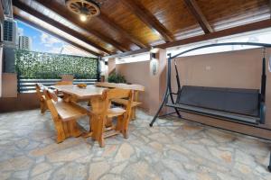 a patio with a table and chairs and a large window at Apartmani Rialto in Kakma