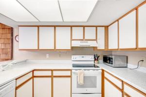 a kitchen with white appliances and wooden cabinets at Sea Colony - 802 Wimbledon in Bethany Beach