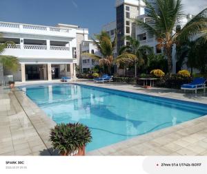 a large swimming pool in front of a building at Rosa Mystica Diani Bnb in Ukunda Airport