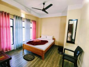 a bedroom with a bed and a ceiling fan at Beaumun Homestay in Bāghdogra
