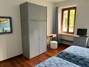 ein Schlafzimmer mit zwei Betten und einem großen Schrank in der Unterkunft Giulia Cottage in Strona