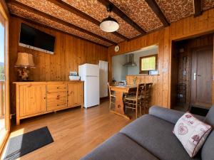 a living room with a couch and a kitchen with a table at Chalet SOL LA MI in Soultzeren +16 photos