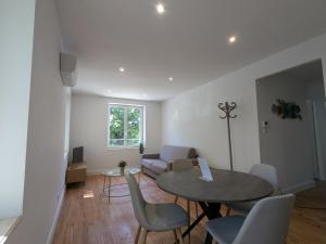 a living room with a table and chairs and a couch at Air-conditioned apartment - two bedrooms in Vichy