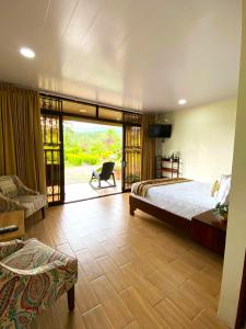 a bedroom with a bed and a sliding glass door at Buganvilia, Cabaña Privada con vista al Volcán Arenal in Palma