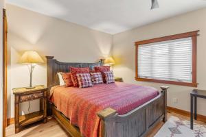 a bedroom with a bed with red pillows and a window at 4BR Townhome Near Canyon Lodge & Lakes Basin in Mammoth Lakes