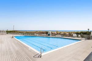 a large swimming pool with a wooden deck at Sea Colony - 3306 Round Robin Way in Bethany Beach