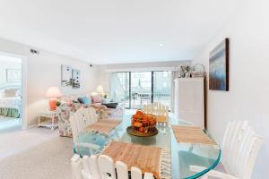 a living room with a glass table and white chairs at Sea Colony - 3306 Round Robin Way in Bethany Beach