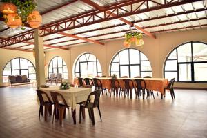 a large room with tables and chairs and windows at Los Portales de Yungar Ecolodge Huaraz in Carhuaz