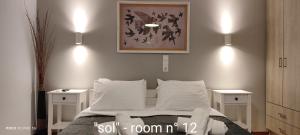 a bedroom with a bed with two white night stands at Papadioti Apartments in Pefki
