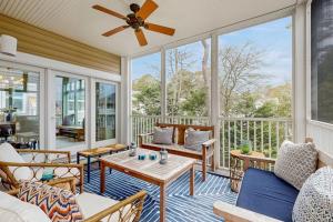 a screened in porch with furniture and a ceiling fan at Sea Colony - 58011 Wimbledon in Bethany Beach