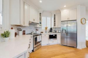 a kitchen with white cabinets and a stainless steel refrigerator at Sea Colony - 58011 Wimbledon in Bethany Beach +44 photos