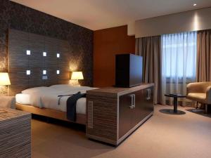 a hotel room with a bed and a flat screen tv at Mercure Hotel Tilburg Centrum in Tilburg