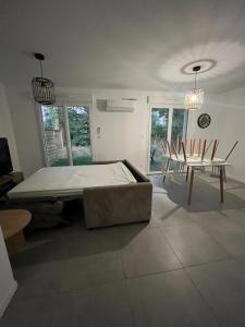 a bedroom with a bed and a table and chairs at Cottage with garden in La Roche-sur-Yon