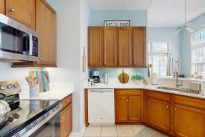 a kitchen with wooden cabinets and white appliances at Bayside Resort - 36295 Sunflower in Selbyville +11 photos