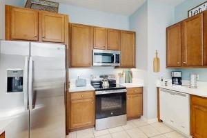 a kitchen with wooden cabinets and a white refrigerator at Bayside Resort - 36295 Sunflower in Selbyville