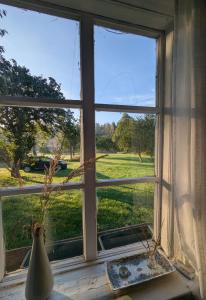 a window with a view of a green field at Pirkia Miške in Kazitiškis