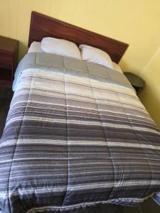 a bed with a striped blanket and two pillows at Lee motel in Nashville