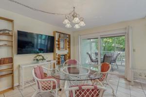 a dining room with a glass table and chairs at Sea Colony - 2004 Doubles in Bethany Beach