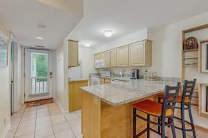 a kitchen with a counter and two bar stools at Sea Colony - 2004 Doubles in Bethany Beach