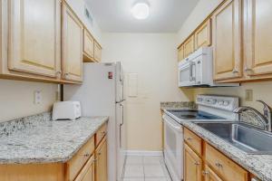 a kitchen with a sink and a white refrigerator at Sea Colony - 2004 Doubles in Bethany Beach +32 photos