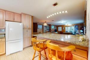 a kitchen with a white refrigerator and wooden cabinets at Sea Del Estates - 38 Sugar Hill in Bethany Beach