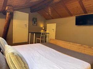 a bedroom with a bed and a flat screen tv at Il Torchio - Guest House Lago Maggiore in Dormelletto