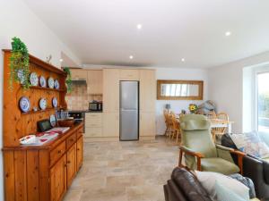 a kitchen and living room with a couch and a table at Farm Cottage in Cemaes Bay