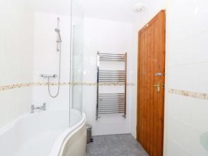 a bathroom with a tub and a toilet and a shower at Farm Cottage in Cemaes Bay +37 photos