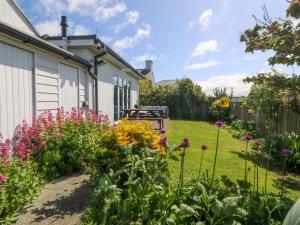 a garden with flowers next to a house at Farm Cottage in Cemaes Bay