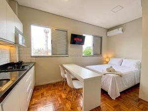 a small room with a bed and a desk in it at Prado Premium Lofts e Kitnets com Ar-Condicionado e TV Smart in Belo Horizonte