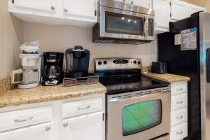 a small kitchen with a stove and a microwave at Bethany West - 609 Brookview in Bethany Beach