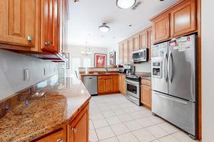 a kitchen with wooden cabinets and stainless steel appliances at Sea Colony - 56032 Great Pine in Bethany Beach +47 photos