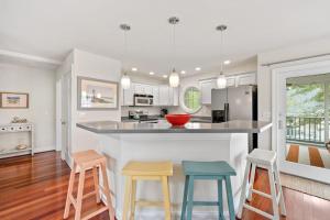 a kitchen with a counter and four stools at Bethany West -- 719 Fenwood in Bethany Beach