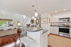 a kitchen and living room with white cabinets and a counter at Bethany West -- 719 Fenwood in Bethany Beach