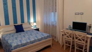 a bedroom with a bed and a desk and a television at B&B Una Rotonda sul mare in Manfredonia