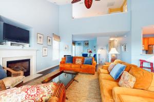 a living room with orange couches and a fireplace at Bear Trap Dunes - 58D October Glory in Ocean View