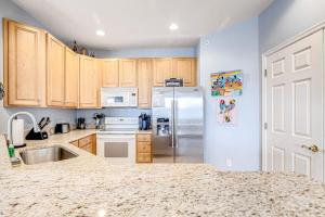 a kitchen with wooden cabinets and a stainless steel refrigerator at Bear Trap Dunes - 58D October Glory in Ocean View