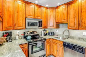 a kitchen with wooden cabinets and stainless steel appliances at Lewes --- 6 Pilot Point in Lewes