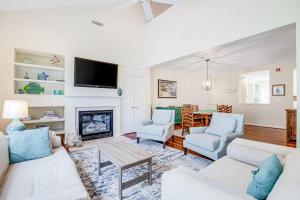a living room with white furniture and a fireplace at Bear Trap Dunes --- 83F October Glory Dunes in Ocean View