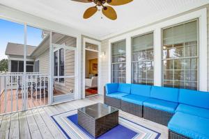 a living room with a blue couch on a porch at Bear Trap Dunes --- 83F October Glory Dunes in Ocean View