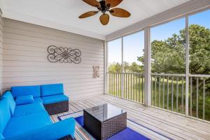 a living room with a blue couch and a ceiling fan at Bear Trap Dunes --- 83F October Glory Dunes in Ocean View