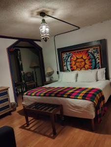 a bedroom with a king sized bed with a colorful blanket at Hotel Rincon de Josefa in Pátzcuaro +2 photos