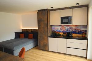 a bedroom with a bed and a kitchen with a tv at Apartments Silvonia in Pallua